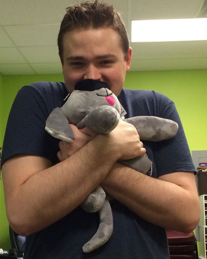 A young man holding Trouble the Dog close
