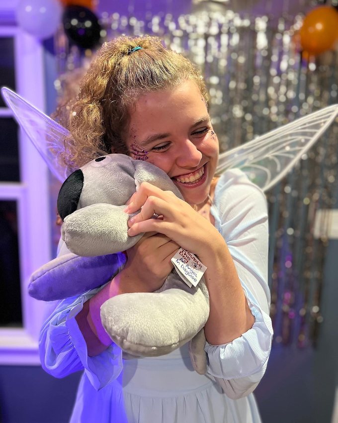 A young woman hugging Trouble the Dog at a celebration